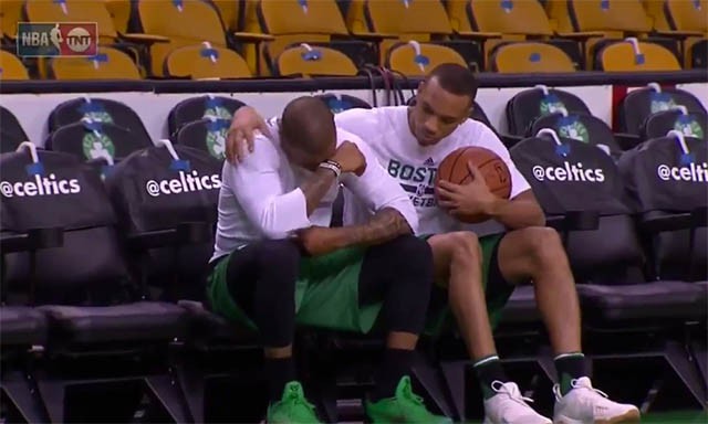 Isaiah cúi gục đầu ngồi khóc với sự an ủi của người đồng đội Avery Bradley.